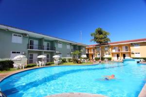 a person swimming in a large pool in a hotel at BOULEVARD DA PRAIA Apart Hotel Beira mar in Porto Seguro