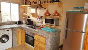a kitchen with a stainless steel refrigerator and a microwave at 4 bedrooms villa with private pool and enclosed garden at Tou Ganaou in Ti nʼ Saïd