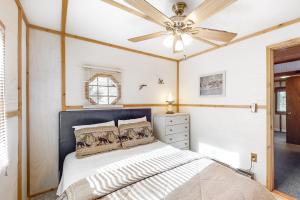 1 dormitorio con 1 cama y ventilador de techo en Catfish Cottages, en Eagle River