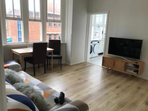 a living room with a couch and a tv and a table at Manly Beach Stays in Sydney