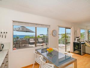 a kitchen and dining room with a view of the ocean at Double the Beach - Opito Bay Holiday Home in Opito Bay
