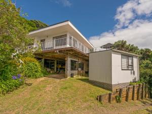 an image of a house with a balcony at Double the Beach - Opito Bay Holiday Home in Opito Bay