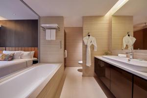 a bathroom with a bed and a tub and a sink at Pan Pacific Serviced Suites Orchard, Singapore in Singapore