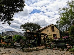 a house with an arch and a garden at Libélula Cabaña- Alojamiento rural in Duitama