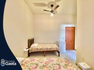 瓜拉帕里的住宿－Pousada Gaeta Meaipe Guarapari，一间卧室配有一张床和吊扇