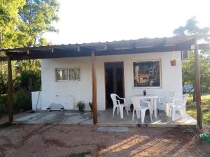 uma pequena casa branca com uma mesa e cadeiras em CandeYaz em Piriápolis