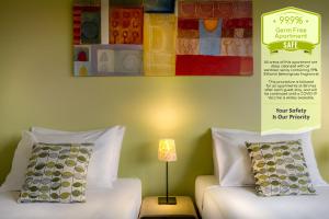 una stanza con due divani bianchi e un cartello sul muro di Birches Serviced Apartments a Melbourne