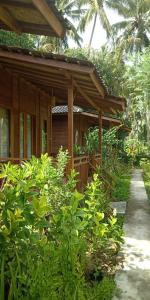 a wooden house with a porch and some plants at Nusa Penida Pudak Nature Bungalow in Nusa Penida