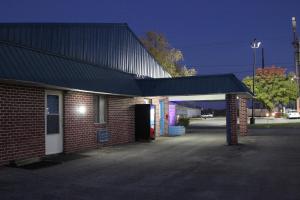 a brick building with a black roof and a garage at Arcola Inn in Arcola