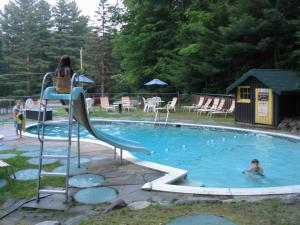 a woman riding a slide in a swimming pool at Amber Lantern Motel in Lake George