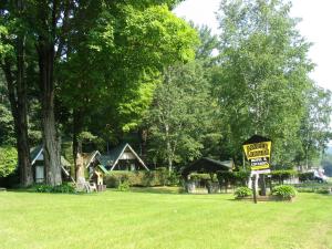 un panneau dans une cour avec un panneau pour la vente dans l'établissement Amber Lantern Motel, à Lake George