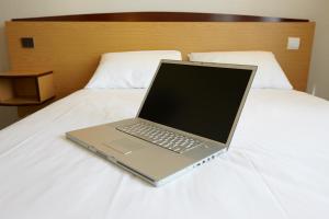 a laptop computer sitting on top of a bed at Campanile Paris 15 - Tour Eiffel in Paris