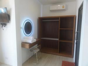a bathroom with a mirror and a closet with a chair at High Life Bungalow in Haad Yao