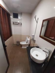 a bathroom with a white sink and a toilet at Homestay 715 in Sa Pa