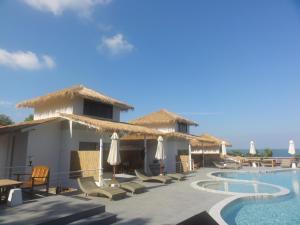 a resort with a swimming pool with chairs and umbrellas at High Life Bungalow in Haad Yao