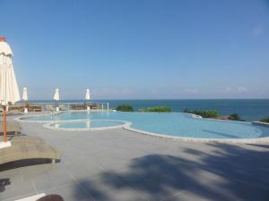 a large swimming pool with the ocean in the background at High Life Bungalow in Haad Yao