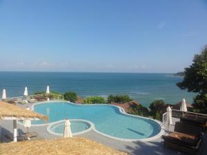 a swimming pool with the ocean in the background at High Life Bungalow in Haad Yao