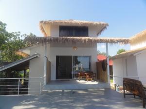 a house with a thatched roof and a patio at High Life Bungalow in Haad Yao