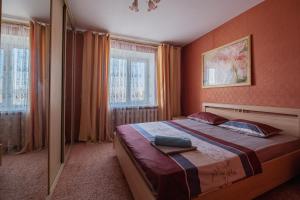 トムスクにあるАпартаменты Красноармейская 135のベッドルーム1室(大型ベッド1台、窓2つ付)