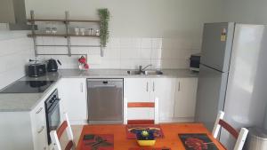 Alkion Villa في واجا واجا: مطبخ مع طاولة وثلاجة