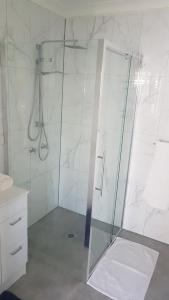 a shower with a glass door in a bathroom at Alkion Villa in Wagga Wagga +4 photos