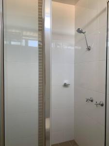 una doccia con porta in vetro in bagno di Charleville Motel a Charleville
