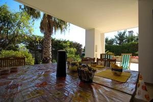 a dining room table with a view of a palm tree at Villa Genny a 500 mt dalla spiaggia in San Cataldo