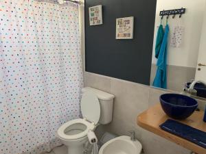 a bathroom with a toilet and a shower curtain at Casa moderna en el bosque y montaña in Villa La Angostura +57 photos