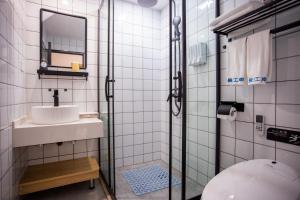 a bathroom with a sink and a toilet and a mirror at 同里泊·晓烟河景民宿 in Suzhou