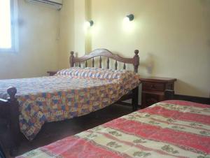 a bedroom with two beds and a dresser and a bed sidx sidx at Hotel Ruma in Salta