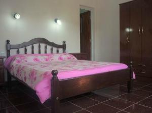 a bedroom with a pink bed with a wooden frame at Hotel Ruma in Salta