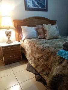 a bedroom with a bed and a night stand with a lamp at Apartment Summer in Puerto Peñasco