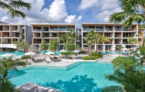 una imagen de una piscina del complejo con palmeras en Wyndham Grand Nai Harn Beach Phuket en Nai Harn Beach