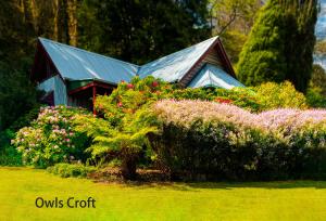 
a house with a flower garden in front of it at Observatory Cottages in Mount Dandenong
