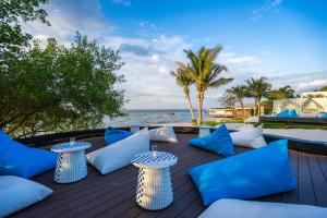 a deck with blue and white pillows and tables at Kram Pattaya in Pattaya North