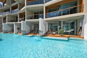 an apartment building with a large swimming pool at Wyndham Grand Nai Harn Beach Phuket in Nai Harn Beach