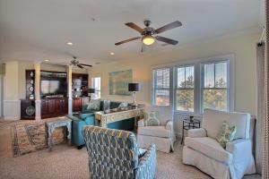 a living room with chairs and a ceiling fan at Hwy 12 Slash Creek Condos in Hatteras