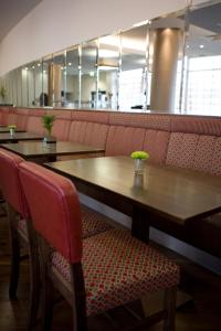 a table and chairs in a restaurant with a table and benches at Leonardo Hotel Aberdeen in Aberdeen