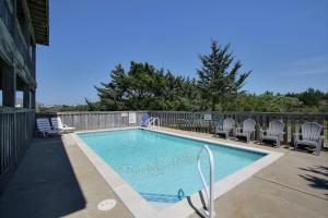 a swimming pool with chairs and a fence at Pamlico Sunset #8-9 in Avon