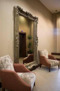a mirror in a waiting room with chairs and a mirror at Leonardo Hotel Aberdeen - Formerly Jurys Inn in Aberdeen