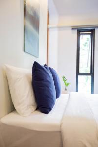 a blue pillow sitting on top of a bed at in My place cafotel in Khlong Thom