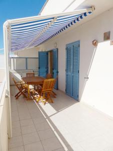 patio con mesa y sillas en el balcón en siciliacasevacanze - Ulivi, en Marina di Ragusa