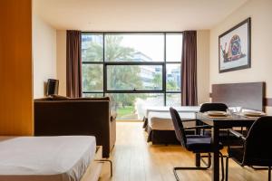 pokój hotelowy z 2 łóżkami, stołem i krzesłami w obiekcie Aparthotel Wellness w mieście Paterna