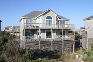 a house with a large deck on a beach at Poetry in Motion #7-K in Avon