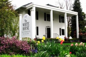 a white house with a sign in the front yard at The White House Bed and Breakfast in Medford