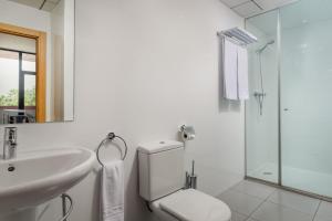 
a bathroom with a toilet, sink, and shower at Aparthotel Wellness in Paterna
