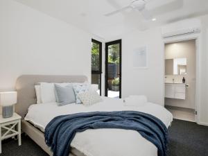 a bedroom with a large bed with a blue blanket on it at Husky Sands I Pet Friendly I 5 Mins Walk to Beach in Huskisson