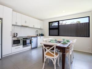 a kitchen with a table and chairs in a kitchen at Husky Sands I Pet Friendly I 5 Mins Walk to Beach in Huskisson