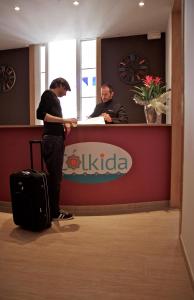 two men standing at a counter in an office at Hostal Colkida in Barcelona