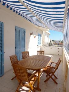 a wooden table and chairs on a patio at siciliacasevacanze - Ulivi in Marina di Ragusa